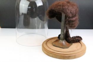 19th Century wig on an antique cast metal stand housed within a glass cloche raised on a wooden