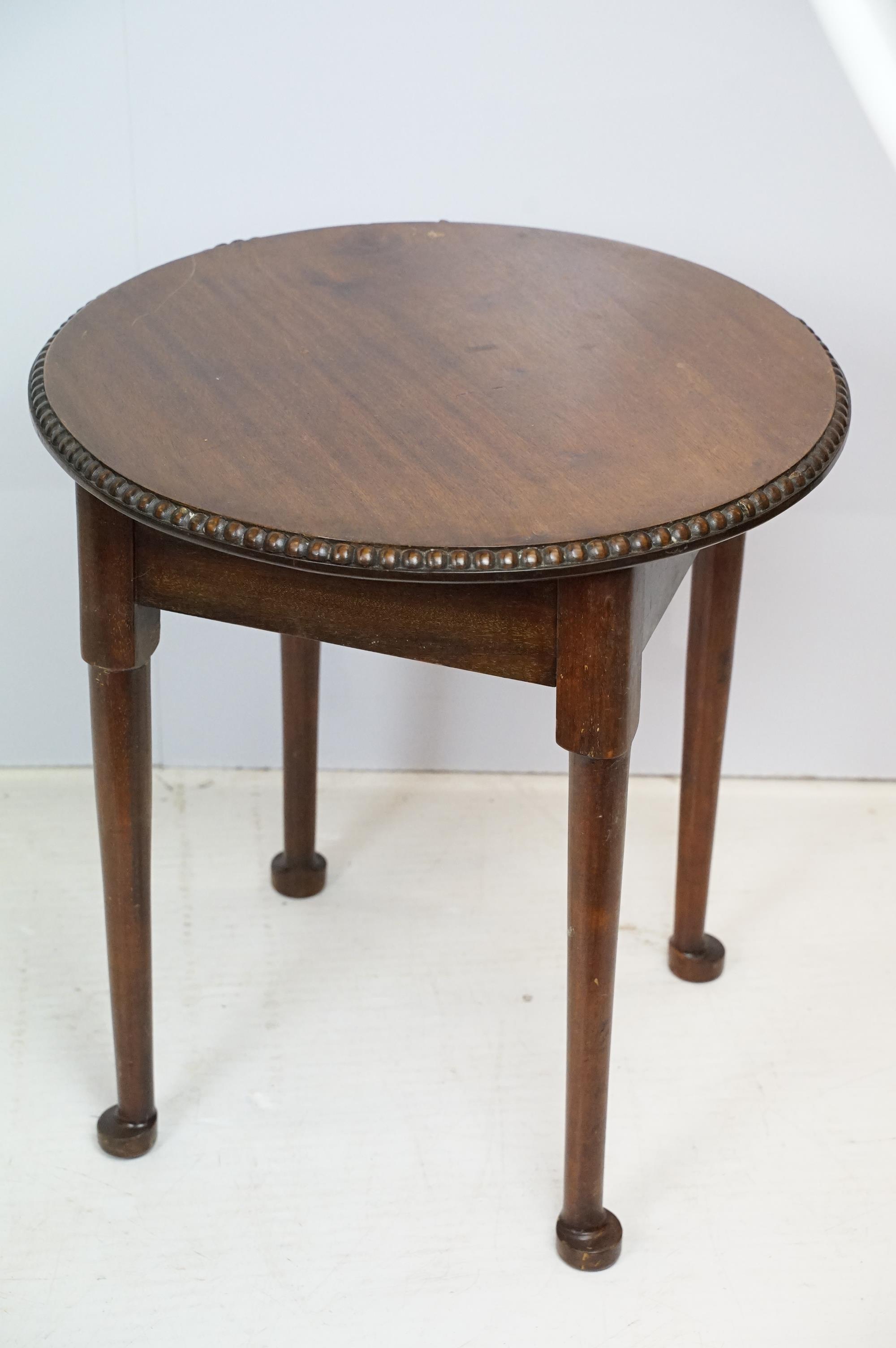 Early 20th Century oak side table having a round top with reeded rim and turned legs. Measures 51