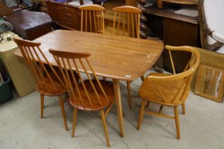 Ercol dining table together with with four Ercol style matching stick back chairs and a carver