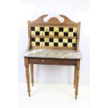 19th Century Victorian oak wash stand having a tile back with marble top raised on turned legs.