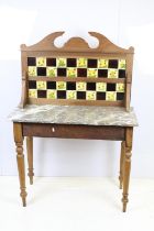 19th Century Victorian oak wash stand having a tile back with marble top raised on turned legs.