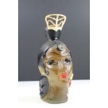 An mid 20th century bottle in the form of a female head complete with contents.