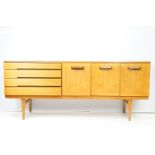 Mid Century teak sideboard having a band of four drawers with fall front cupboard to centre beside