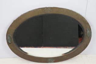 Early 20th Century Arts and Crafts oval copper framed mirror having hammered detailing with oval