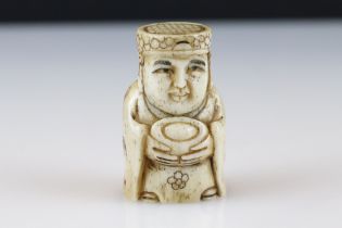 A signed ox bone netsuke of an oriental figure with indigo, approx 5.5cm