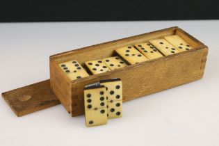 A set of early 20th century bone dominoes within wooden case.