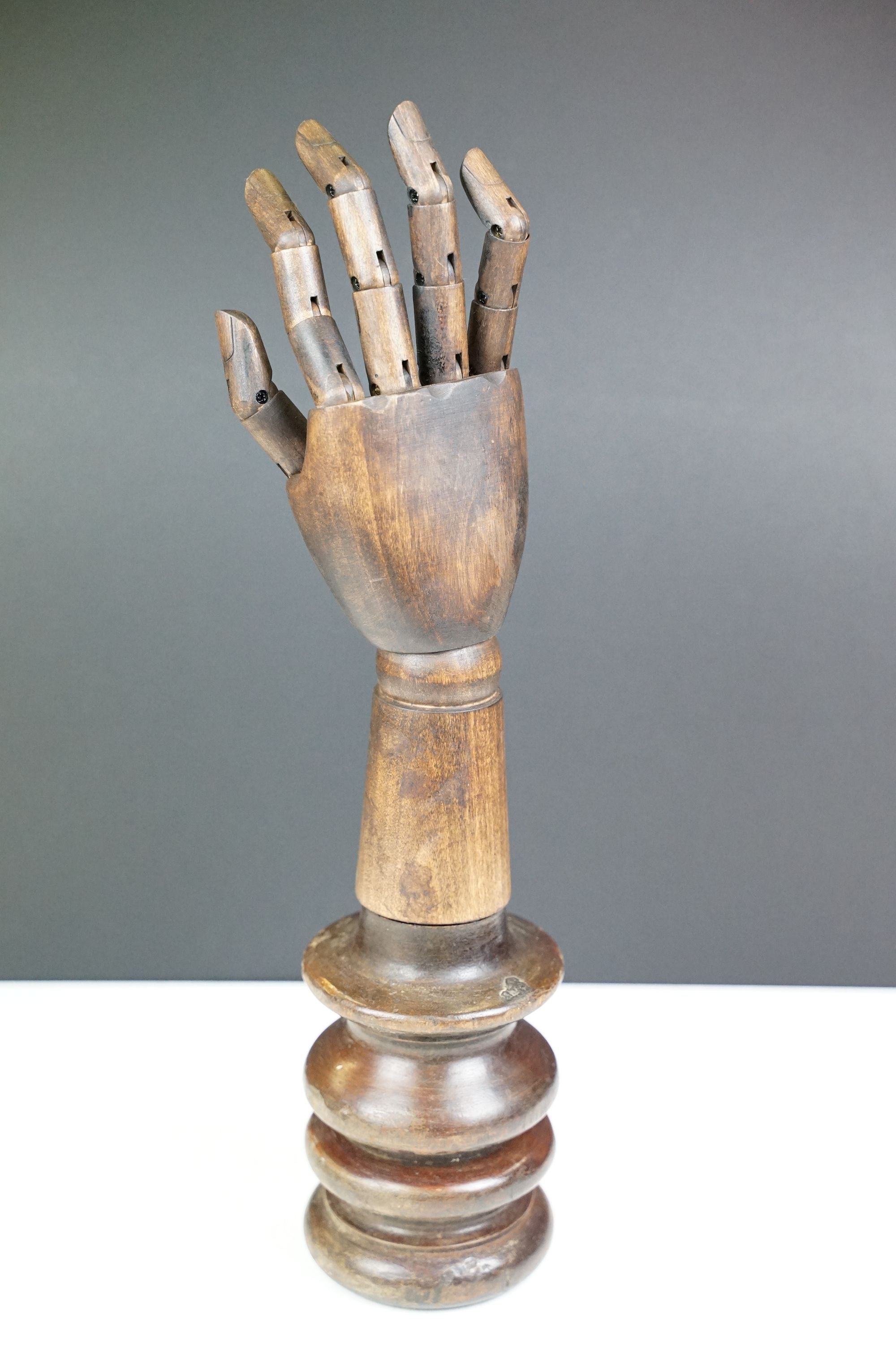 Artist model hand with articulated fingers, raised on a turned wooden base, approx 44cm high