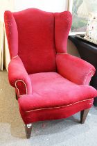 20th Century red velvet wing backed arm chair raised on tapering oak legs. Measures 102 x 82cm.