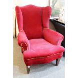 20th Century red velvet wing backed arm chair raised on tapering oak legs. Measures 102 x 82cm.