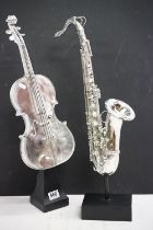 Two resin musical instrument models to include a violin and saxophone, with chrome effect finish. (
