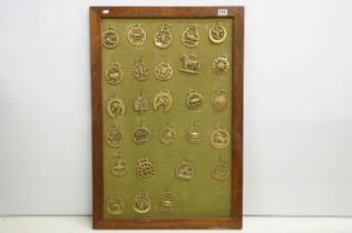 Collection of antique horse brasses mounted to canvas covered board and framed. Measures 97 x 66cm.