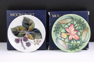 Two boxed Moorcroft pottery pin dishes to include a Bramble Pattern and green ground floral example,