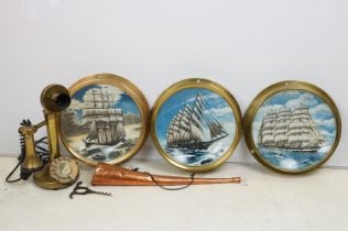 Three glazed brass portholes housing nautical collectors plates, together with a brass candlestick