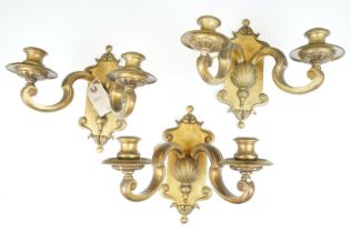 Three cast brass Queen Anne style Dutch brass twin branch wall sconce lights with shell motifs.
