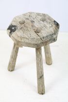 Weathered elm three legged milking stool with octagonal top. Measures 34cm tall.