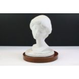 Lladro ceramic bust of a girl raised on a wooden base. Mark to base. Measures 23cm tall.