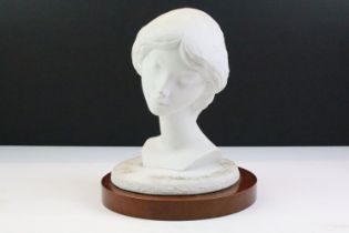 Lladro ceramic bust of a girl raised on a wooden base. Mark to base. Measures 23cm tall.