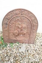 Antique cast iron fire back with relief decoration of a figure riding a horse, approx 59cm tall