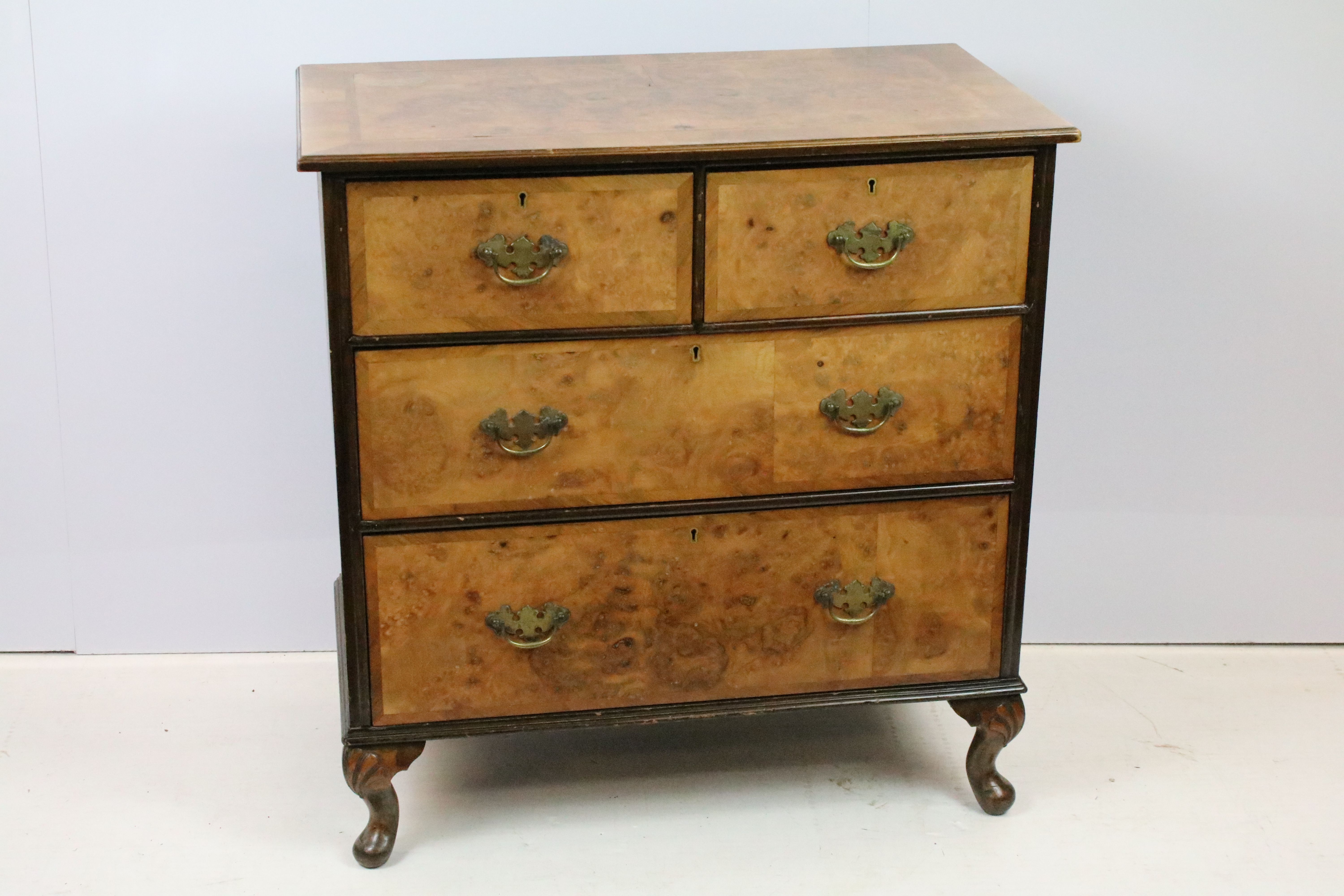 20th Century walnut veneered chest of drawers having two over two drawers with brass swing handles