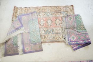 Group of three rugs to include two kilim rugs with pink, purple and green patterning and a cream