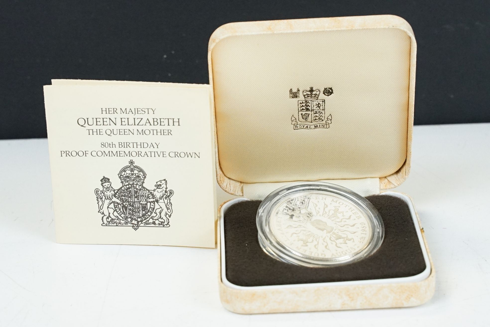 A Royal Mint silver proof Queen Mother 80th Birthday crown coin encapsulated within fitted display