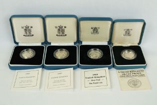 A collection of four Royal Mint silver proof £1 coins to include 2002, 2003, 1989 and 1984 examples,