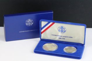 A cased United States of America Liberty coin set comprising of the 1986 silver dollar and half