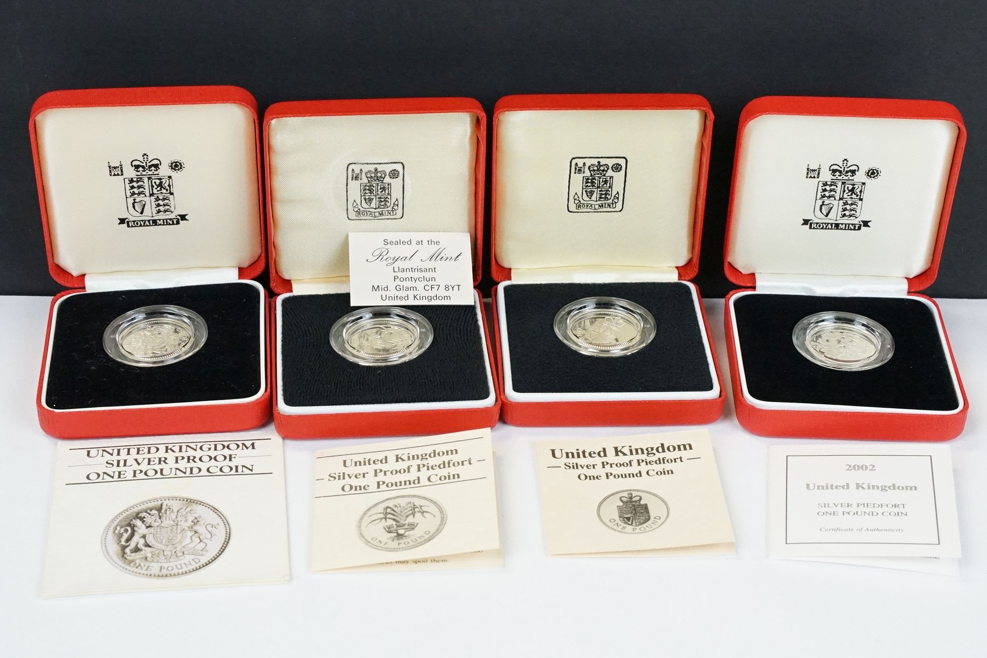 A collection of four Royal Mint silver proof £1 coins to include 2002, 1985, 1983 and 1988 examples,