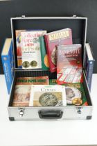 A collection of coin and banknote collectors reference books contained within an aluminium storage