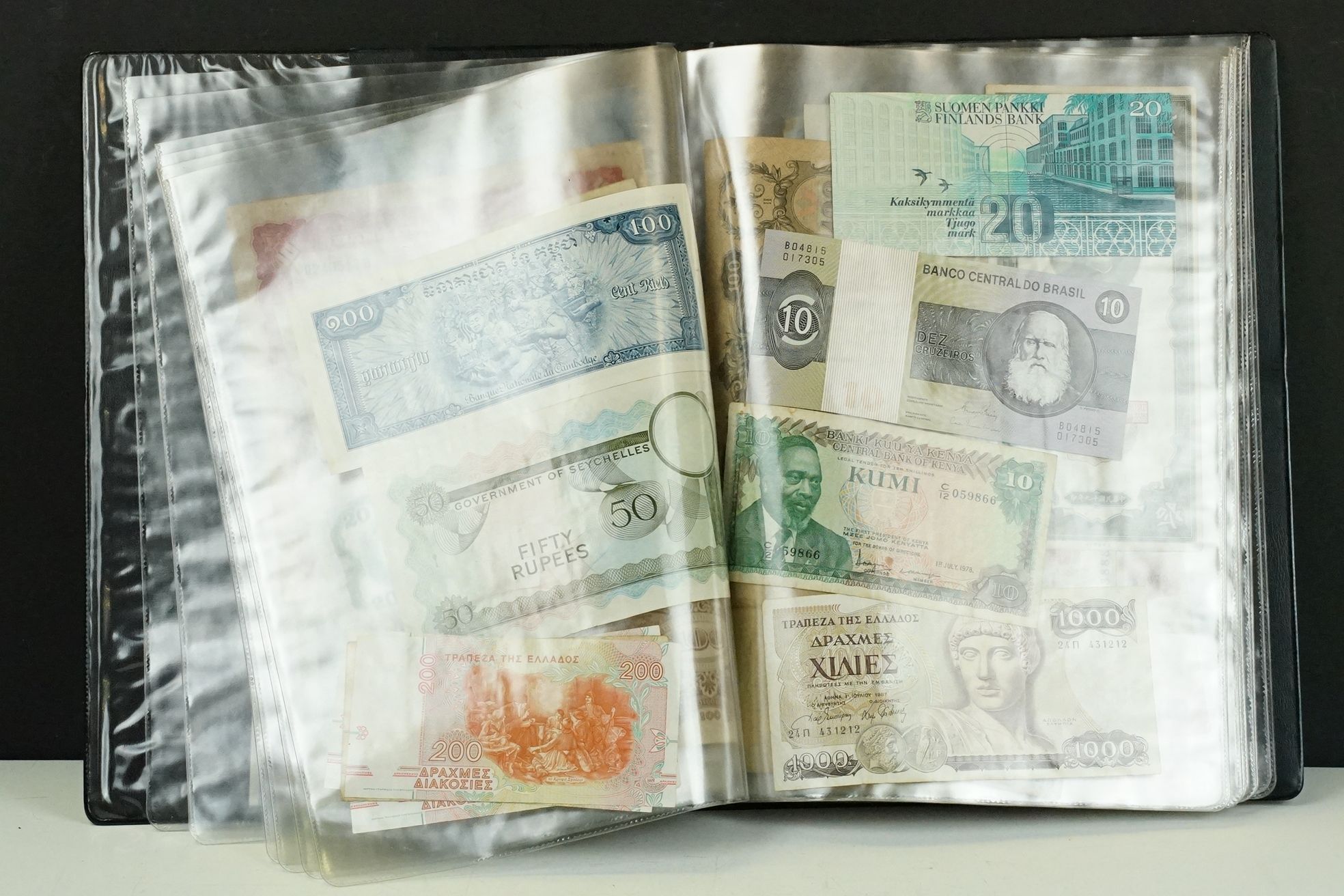 A collection of British and World banknotes contained within a folder to include China, Germany,