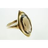 9ct gold and smoky quartz ring. The ring being bezel set with an oval cut smoky quartz in a marquise