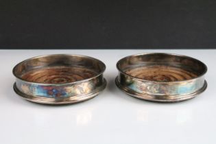 Pair of silver hallmarked wine coasters having turned wooden bases with beaded rim. Hallmarked