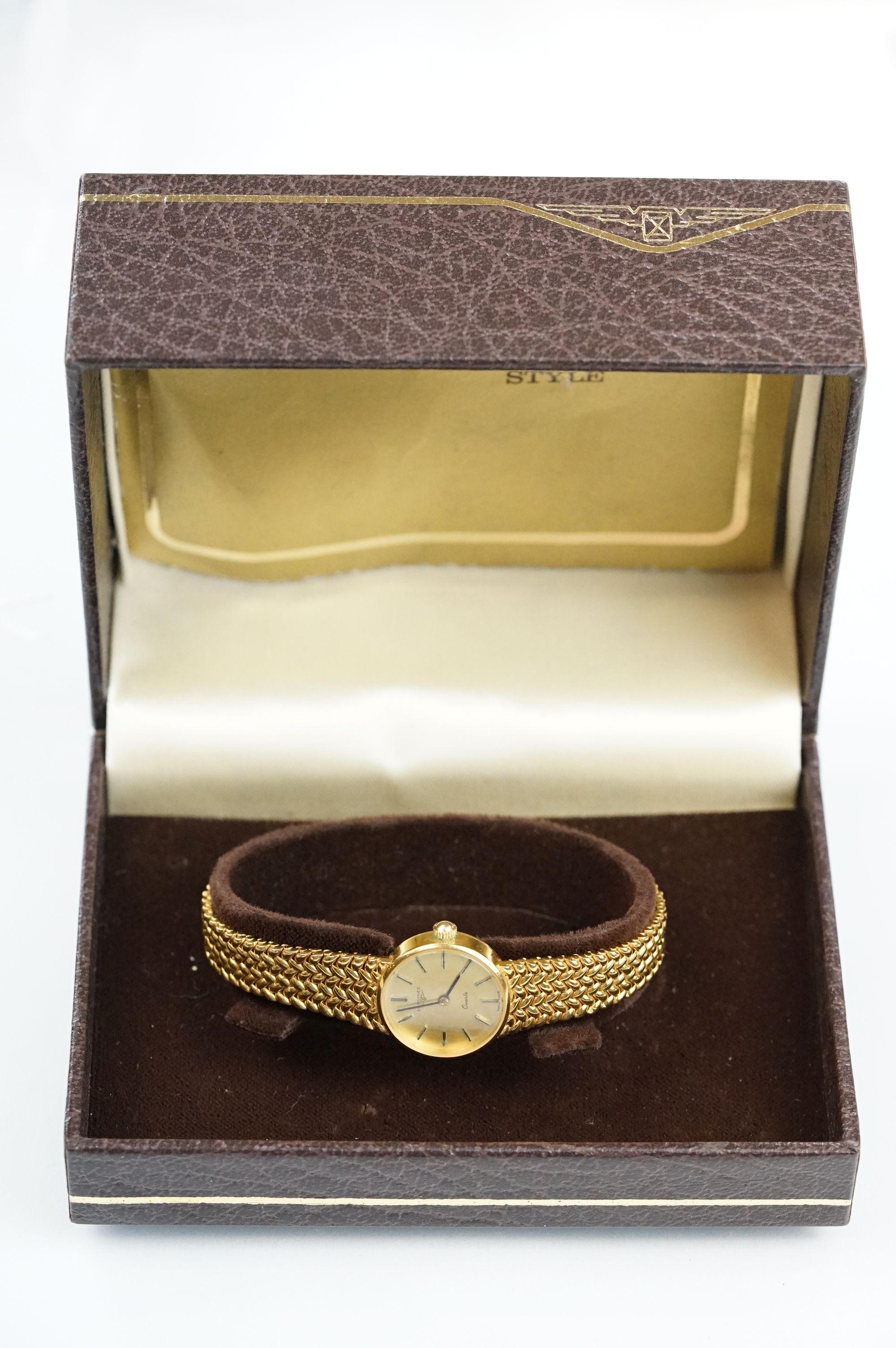 9ct gold Longines quartz wrist watch having a round face with baton numerals mounted to a knitted