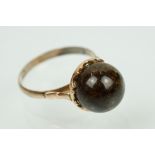 Vintage orb ring set with a brown stone orb to head set within a pierced mount set to a plain shank.