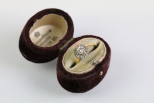Early 20th Century diamond cluster ring. The ring being set with an old round cut diamond to