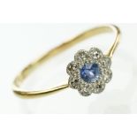 18ct gold sapphire and diamond daisy cluster ring. The ring being set with a round cut blue sapphire