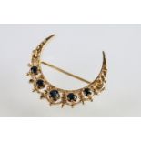 9ct gold hallmarked crescent brooch set with five round cut sapphires with pierced details.