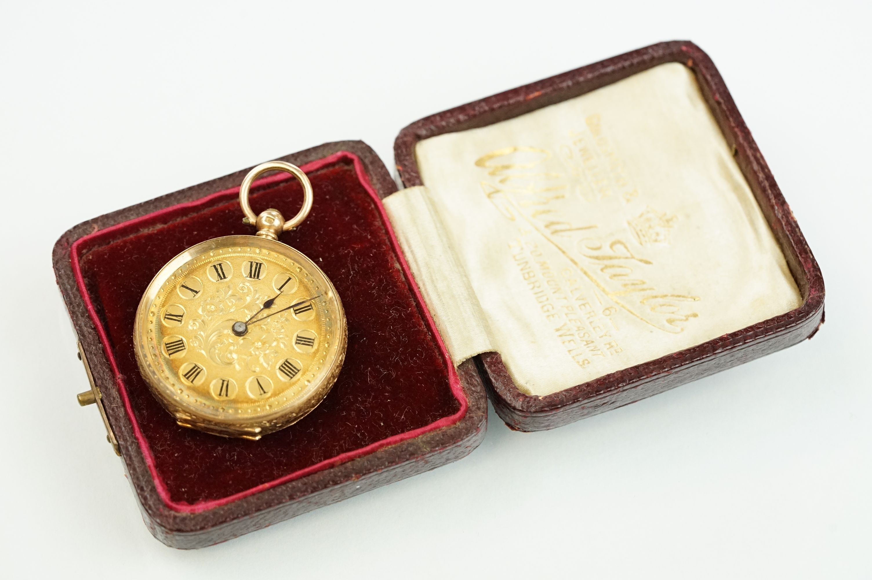 14ct gold open face pocket fob watch having a gilt face with foliate details and roman numerals to