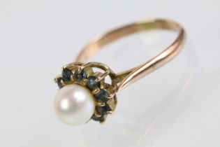 Gold pearl and blue stone ring. The ring being set with a pearl to cultured centre with a halo of