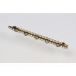 Early 20th Century diamond and pearl bar brooch being set with five round cut diamonds in millegrain