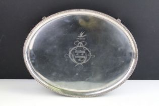 George III silver hallmarked oval salver tray having a beaded rim with engraved plate and scrolled