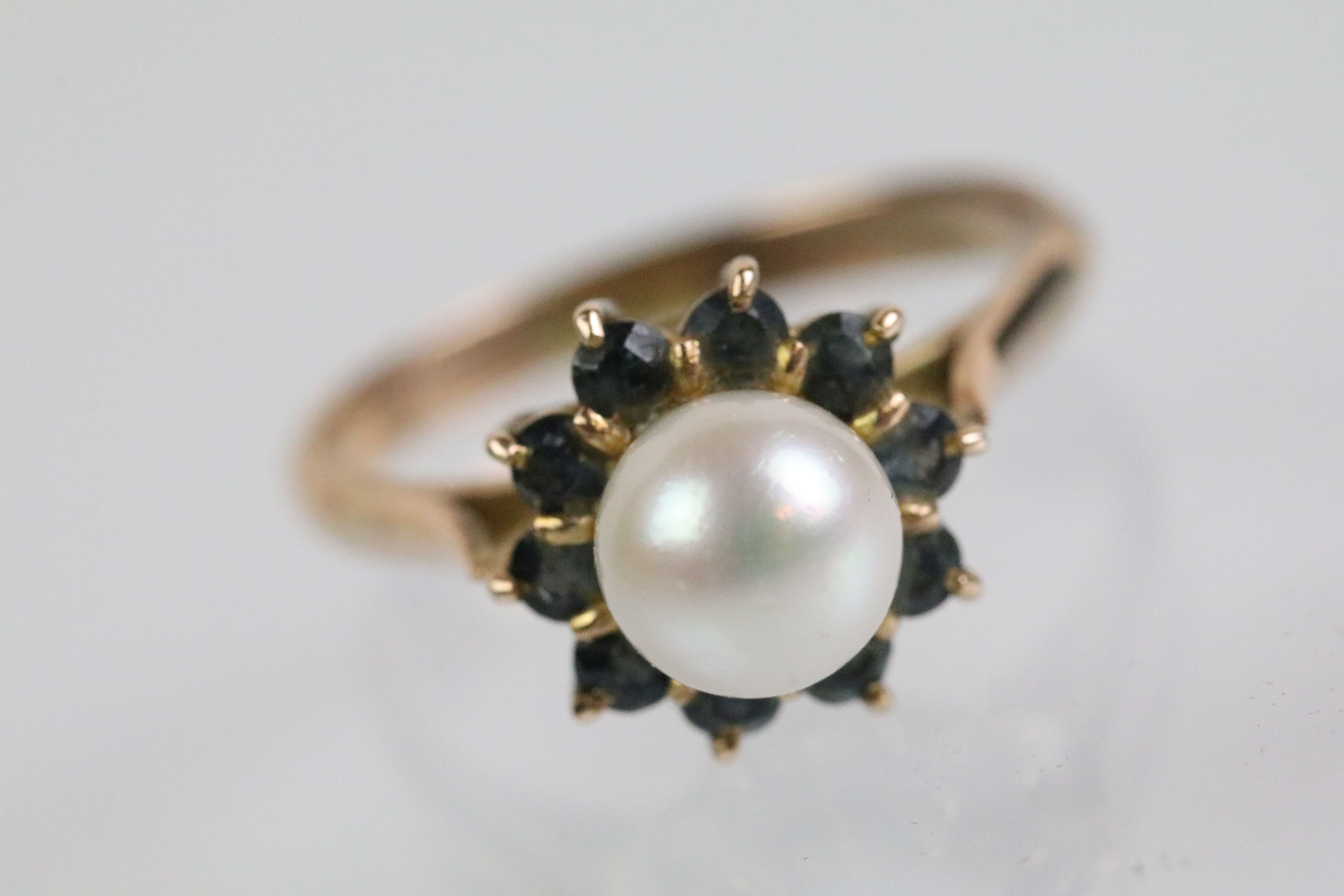 Gold pearl and blue stone ring. The ring being set with a pearl to cultured centre with a halo of - Image 2 of 4