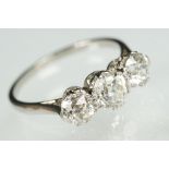 Three stone diamond and platinum ring. The ring being set with three round old cut diamonds in prong