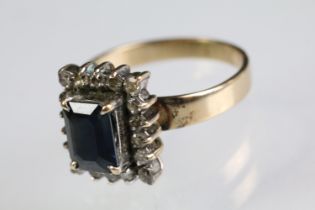 18ct gold sapphire and diamond cluster ring. The ring being set with a rectangular step cut sapphire