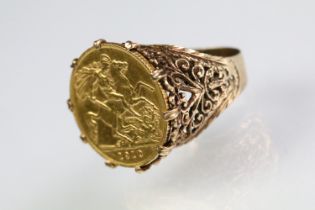 1910 half sovereign set into a 9ct gold pierced scrolled detail ring mount. Hallmarked 9ct to