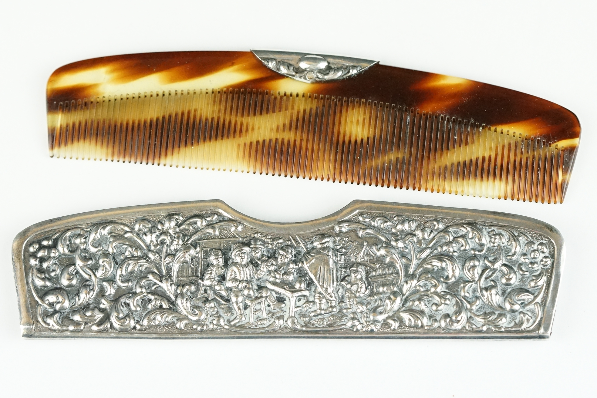 An antique sterling silver repoussé pattern hair comb and case.