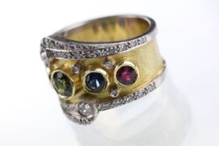 18ct gold, ruby, sapphire and diamond ring. The ring bezel set with a green round cut sapphire to