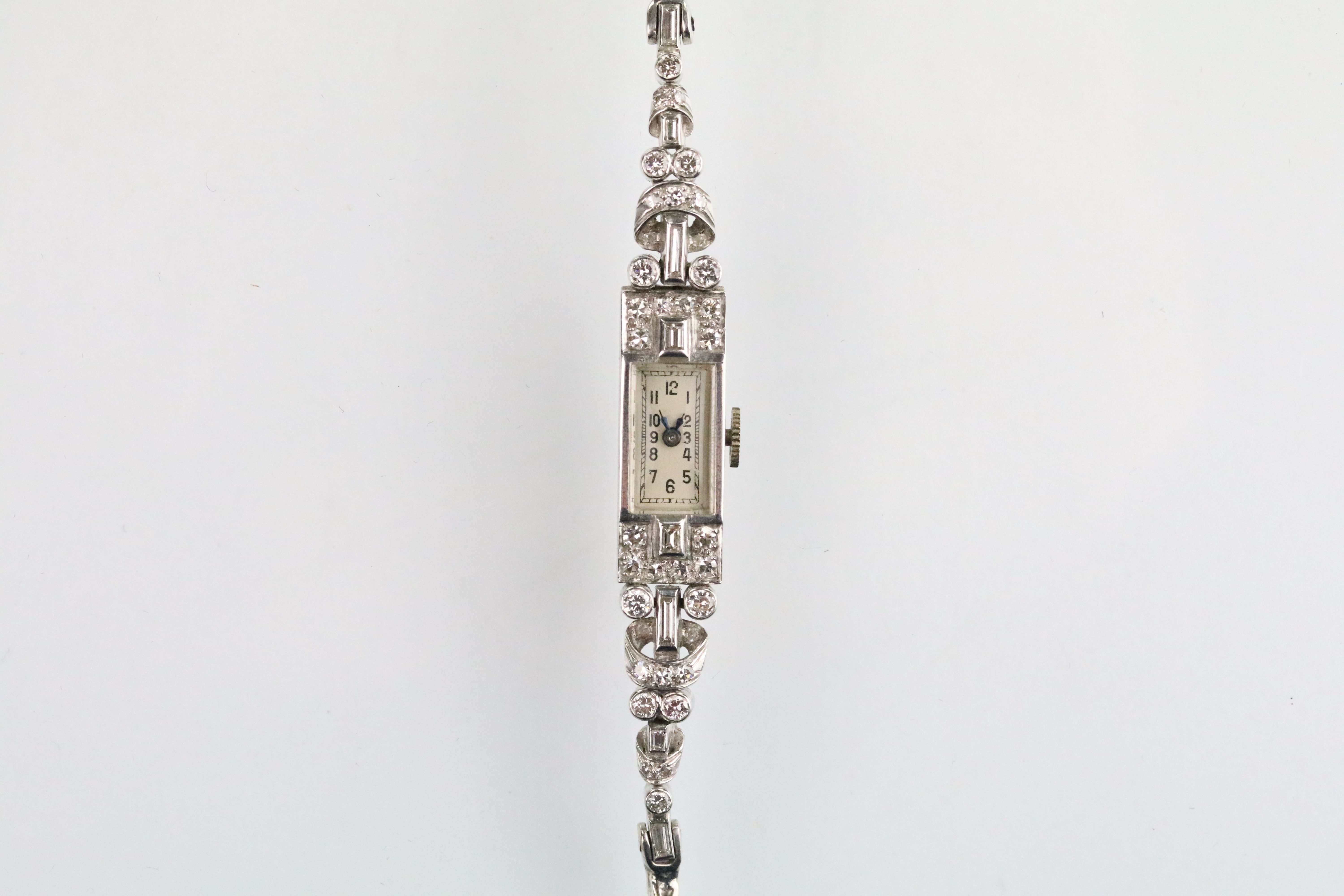 Mid 20th Century platinum, white gold and diamond dress watch. The watch having a rectangular face