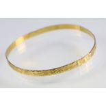 Incised closed bangle bracelet with geometric details. Yellow metal marked 22. Measures 6cm wide.