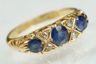 18ct gold sapphire and diamond ring. The ring being set with a central oval cut sapphire to centre